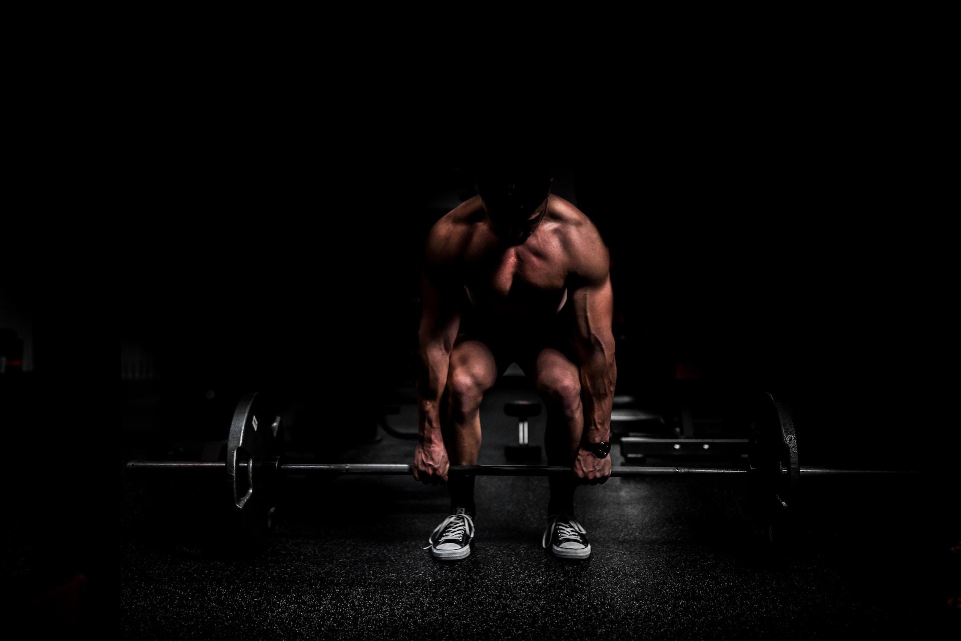 Man getting ready to pick up a barbell off the floor to gain muscle.