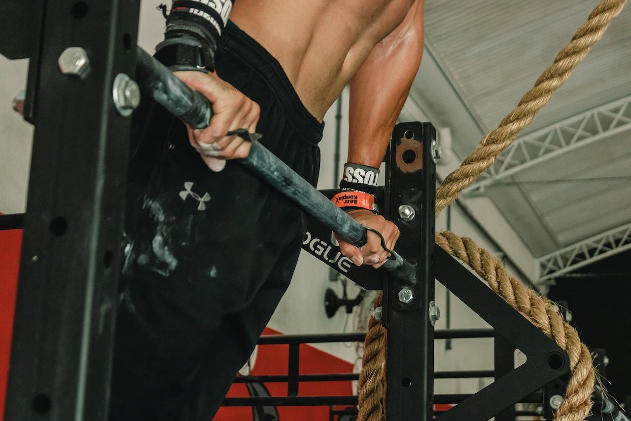 Picture of a man holding on to a bar inside a gym.